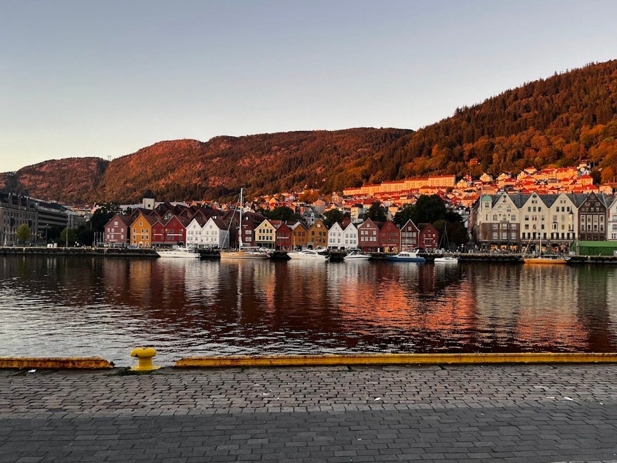 Golden evening light reflected across Bergen harbour and the historic Bryggen wharf