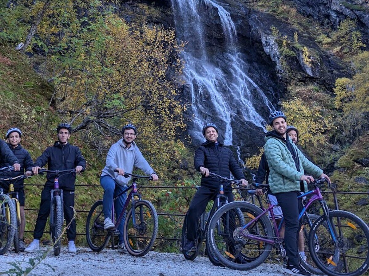 Cycling down the Flåmsdalen valley in front of a cascading waterfall